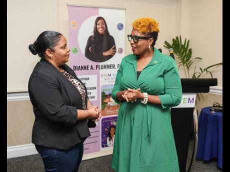 Dr Natwaine Gardner (left), principal director, science, Ministry of Science, Energy, Telecommunications and Transport, and Sophia Lewis, head of the Jamaica Public Service Foundation, exchange thoughts on Plummer’s STEM education book series.
