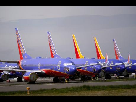 
A line of Southwest Air Boeing 737 jets are parked near the company’s production plant while being stored at Paine Field, on Friday, April 23, 2021, in Everett, Washington. 