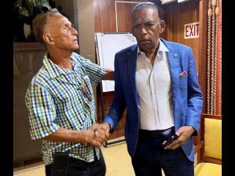 New Jamaica Cricket Association (JCA) president Dr Donovan Bennett (left) is congratulated by outgoing president  Wilford ‘Billy’ Heaven following the election of officers at the JCA’s annual general meeting held at the Jamaica Conference Centre yest