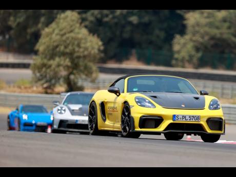 A fleet of Porsches takes to the circuit, showcasing the brand’s diverse lineup and exhilarating driving dynamics.