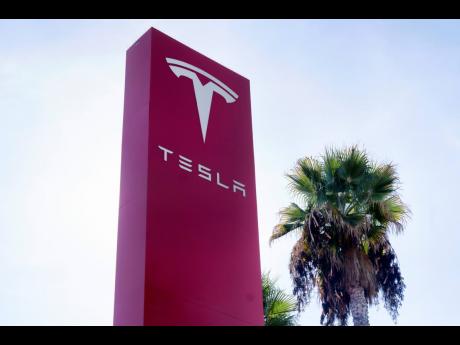 
A Tesla sign is seen at a dealership, December 3, 2023, in Buena Park, California.