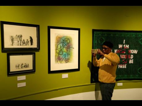 Artist Michael Selekane takes a photograph of his work at an exhibition at the Apartheid Museum in Johannesburg, South Africa.