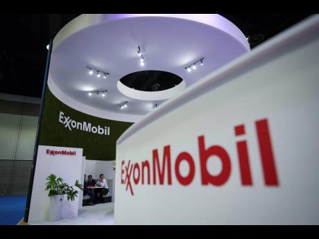 
In this July 11, 2023 photo, delegates meet at the Exxon Mobil booth during the LNG2023 conference in Vancouver, British Columbia.