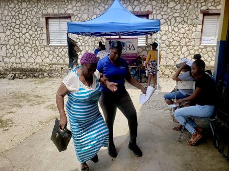 Retrieve resident Violet Samuels being assisted by Jannette Burke, health promotion and education officer at the Hanover Health Services, during a health fair at the Pondside Primary and Infant School in Hanover on Friday.