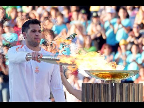 Greek Olympic medallist Ioannis Fountoulis lights the caldron with the Olympic Flame during the Olympic flame handover ceremony at Panathenaic stadium, where the first modern games were held in 1896, in Athens, on Friday, April 26. On Saturday the flame bo