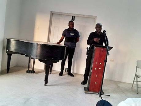 Inspector of Police Godfrey Lawrence (right), officer in charge of the newly-opened Hopewell Police Station in Hanover, addressing a community meeting at Hopewell Sports Complex and Community Centre in Orchard Housing Scheme on Saturday. Constable Errol Wa
