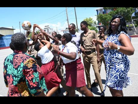 Acting Principal Yvette Ricards Thompson (right); Rohan Johnson (centre), acting vice-principal; and Novette Christian (left), vice-principal, interact with their students at the Denham Town High School in Kingston on Tuesday.