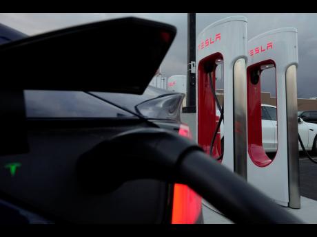 
An electric vehicle charges at a Tesla Supercharger station in Detroit seen on November 16, 2022.