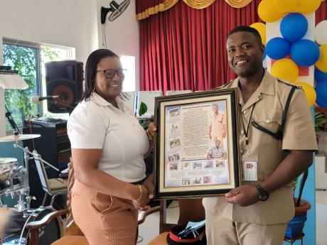 Inspector Ricardo Beckford collects a special award from Ava Lawrence of the Alexandria Stakeholders Committee.