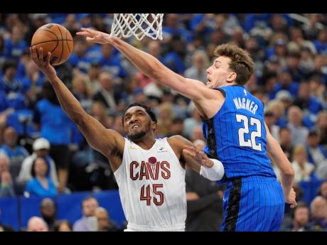 AP 
Cleveland Cavaliers guard Donovan Mitchell (left) takes a shot around Orlando Magic forward Franz Wagner during the first half of Game 6 of an NBA basketball first-round play-off series on Friday.