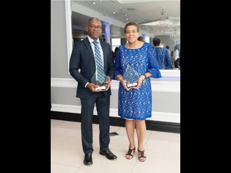 TWO THANK YOUs. Honourees Dr Sunil Stephenson (left), UWI Mona, for humanitarian service, and Normadelle Rose, manager, RJRGLEANER, NA, for community service; display their tokens presented at the OID Spring Luncheon Fundraiser at the Greentree Country Clu