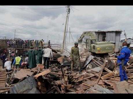 A bulldozer demolishes houses on riparian land in the Mukuru area of Nairobi, Kenya, yesterday. The government ordered the demolition of structures and buildings, illegally constructed along riparian areas. Kenya, along with other parts of East Africa, has