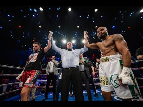 Referee Martin Forest (centre) holds up the hands of Erik Banzinyan (left) and Shakeel Phinn after their drawn title fight at the Cadino de Montreal in Canada last Thursday. 