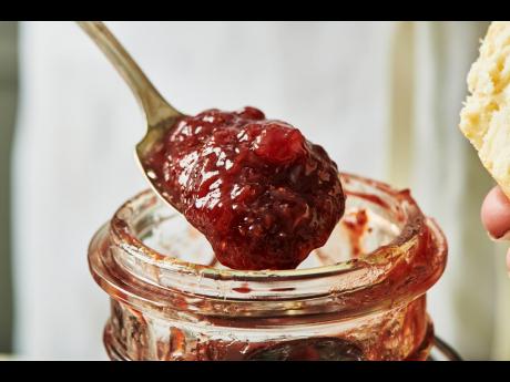 This image shows a jar of strawberry jam with uncrushed berries adding texture to the mixture. 