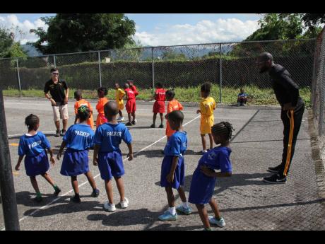 In this 2019 photo Akira Kanehama, Japan International Cooperation Agency (JICA) volunteer and Timol Stanberry, PE teacher, teach a group of kindergarten students of Tarrant Primary School to stretch. 