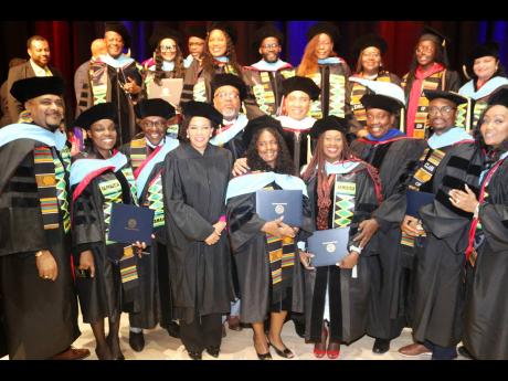 PM Holness (centre), along with Ambassador Audrey Marks and Robert Montague, member of parliament for St. Mary West, share with Jamaican graduates of the Delaware State University at the 2024 commencement ceremony on Friday May 10, at the university’s ca