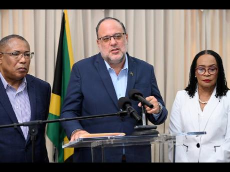 Opposition Leader Mark Golding (centre) is flanked by Parliamentarians Anthony Hylton and Senator Donna Scott-Mottley, members of the Constitutional Reform Committee, during a press conference hel last Tuesday at the Office of the Leader of the Opposition 