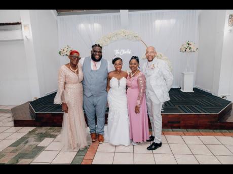 Surrounded by love, the bride and groom (centre) pose with their parents (from left) Ever Pryce, Julene Martin and Gary Martin.