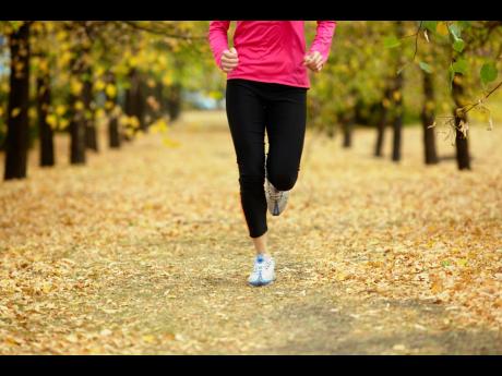 Image of female legs jogging among autumn trees.
