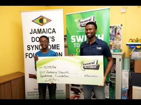 Thirteen-year-old Jamaica Down’s Syndrome Foundation member Denville Jennings, this year’s designated recipient of General Accident Insurance Company’s (GenAc) annual donation to the foundation, receives the symbolic cheque from GenAc marketing assoc