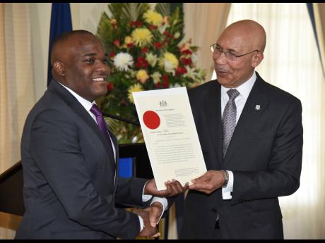 Governor General Sir Patrick Allen (right) presents the instrument of appointment to Senator Abka Fitz-Henley shortly after appointing him as parliamentary secretary in the Office of the Prime Minister at King’s House in St Andrew on Wednesday.