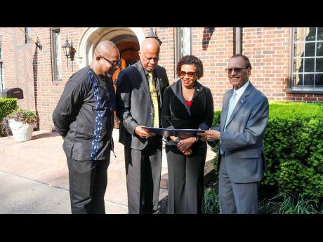 Jamaica’s Ambassador to the United States, Audrey Marks, along with (from left) UWI Mona principal Professor Densel Williams; UWI Vice-Chancellor Sir Hilary Beckles; and SUNY Buffalo President Satish K. Tripathi peruse the memorandum of understanding bet