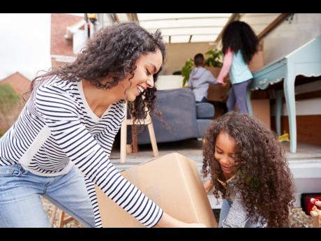 Representational image of a mother and her children unloading furniture.