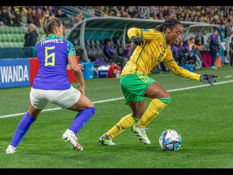 Reggae Girlz’ Tiffany Cameron (right) takes on Brazil’s Tamirez during a Women’s World Cup first-round game at the Melbourne Rectangular Stadium in Australia last year.