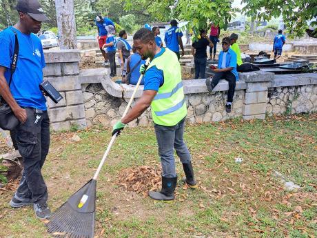 Montego Bay Mayor Richard Vernon (centre) takes part in cleaning and beautification work at the Pye River Cemetery in Bogue, Montego Bay, St James, during Labour Day activities on Thursday, May 23, 2024. The Labour Day parish projects for St James involved