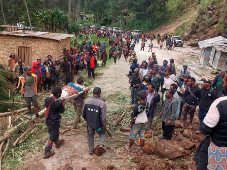 In this photo provided by the International Organization for Migration, an injured person is carried on a stretcher to seek medical assistance after a landslide in Yambali village, Papua New Guinea, Friday, May 24.