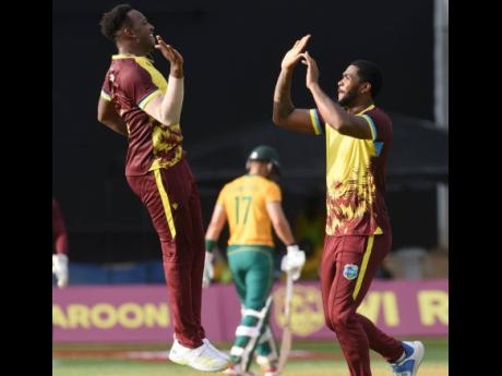 West Indies bowlers Matthew Forde (left) and Obed McKoy celebrate after the fall of a South African wicket during the first T20 International match at Sabina Park on Thursday.