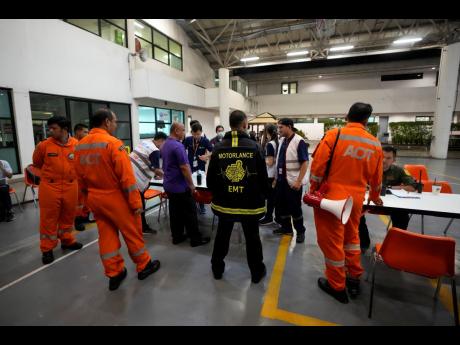 Members of a rescue team discuss after a London-Singapore flight was diverted to Bangkok due to severe turbulence, in Bangkok, Thailand, Tuesday, May 21, 2024.