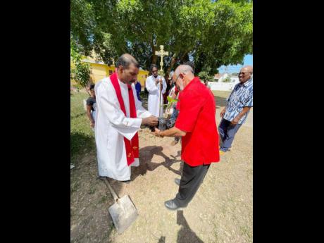 People’s warden, Raymond Goffe, presents a breadfruit sapling for planting.
