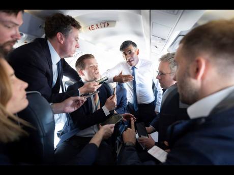 British Prime Minister Rishi Sunak talks to journalists on his plane as he travels from Northern Ireland to Birmingham during a day of campaigning for this year’s general election due to be held on July 4, on Friday.
