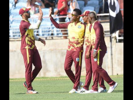 
From left: West Indies captain Brandon King, Akeal Hosein, Gudakesh Motie, and Fabian Allen celebrate the wicket of South Africa’s Quinton de Kock during the second T20 International between the teams at Sabina Park yesterday.