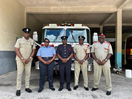 District Officer Christopher Brown (centre), Jamaica Fire Brigade, connects with colleagues from the Royal Police Force of Antigua & Barbuda - St John’s Fire Department - (from left) Inspector Robert Neptune, Corporal Marline Carr-Henry and supertindents