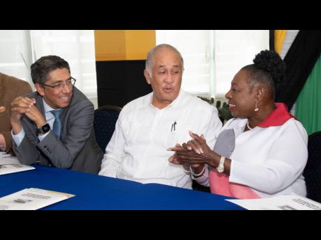 Olivia Grange, minister of culture, gender, entertainment and sport, in discussion with Chairman of Carib Cement Parris Lyew-Ayee (centre) and the company’s managing director, Jorge Martinez, during the signing of an agreement for the upgrade and re-open