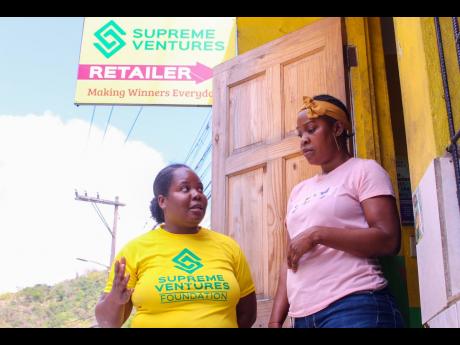 Supreme Ventures Limited’s Corporate Communications and PR Manager Chloleen Daley-Muschett, and ‘Supreme Hero’ Anesha Miller discuss Labour Day activities in the Look Out Community of Gordon Town, St Andrew, last Thursday.