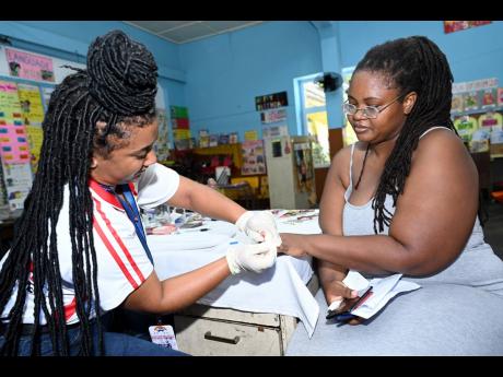 left: Nurse Yolanda Warburton (left), of Ashish Health Care Centre, checks Rae Town resident Normalee Jones’ blood sugar levels.