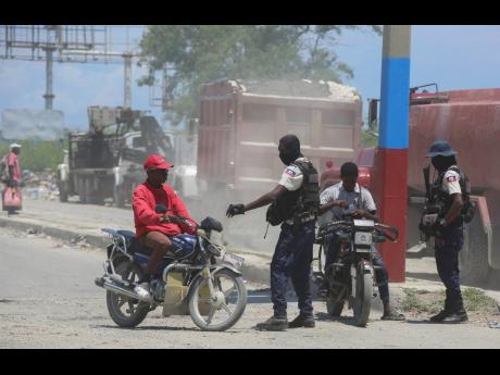 Police check motorcyclists near the airport in Port-au-Prince, Haiti, on Friday, May 24.