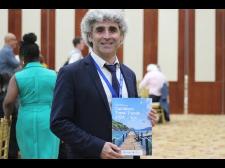 Olivier Ponti, director of intelligence and marketing at ForwardKeys, displaying the Caribbean Travel Trends 2024 report at the 2024 Caribbean Hotel and Tourism Association’s ‘Travel Forum’ on Monday, May 20 at the Montego Bay Conference Centre in St