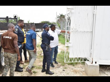 Howard Ward (right), chairman of the Howard Ward Benefit Foundation,shows Acting Senior Superintendent of Police for St James Eron Samuels (centre) and member of the St James Police Special Operations team the inside of their new operational base and admin