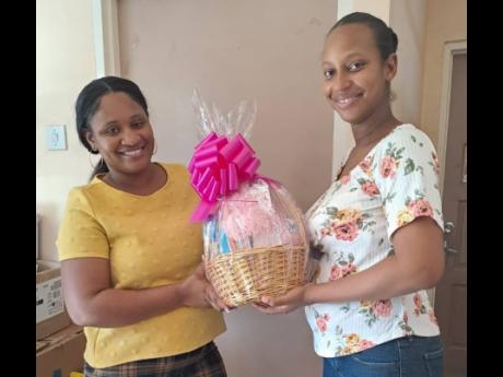 Clover Blake Bell (right), a mother who gave birth at the Black River Hospital in St Elizabeth, receives a contribution from donor Tianta Morrel as part of the New BIRTH programme which was launched at the hospital in 2022.