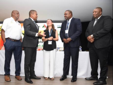 From left: Franklin Witter, minister of state in the Ministry of Agriculture, Fisheries and Mining, in conversation with Floyd Green, minister of agriculture and mining; Maria Teresa Vera, chair, Tephritid Workers of the Western Hemisphere; Damian Rowe, ac