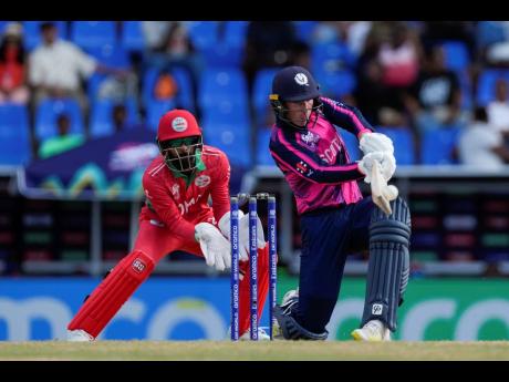 Scotland’s Brandon McMullen plays a shot as Oman wicketkeeper Pratik Athavale looks on during an ICC Men’s T20 World Cup match at the Sir Vivian Richards Stadium in North Sound, Antigua and Barbuda, yesterday.
