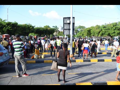 Stranded commuters await Jamaica Urban Transit Company buses in downtown Kingston as taxi operators began what they said will be a week-long protest on Monday.