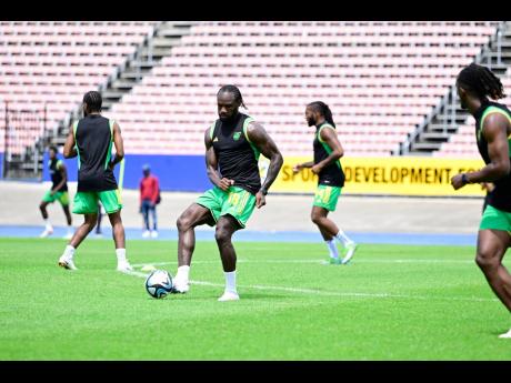 Reggae Boy Michail Antonio (centre) makes a pass during a training drill at the National Stadium on Wednesday.