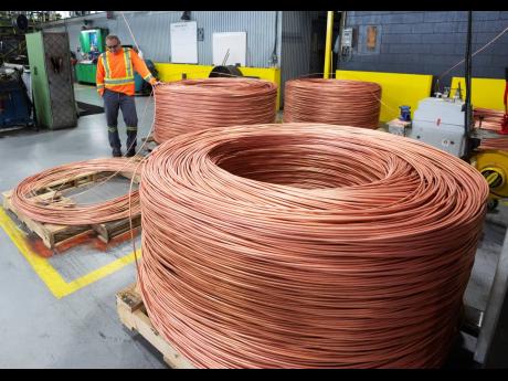 
A worker looks at a coil at Nexans, one of the world’s largest wire and cable manufacturers, Friday, April 12, 2024, near Montreal. The company is mixing more and more scrap copper into its products.