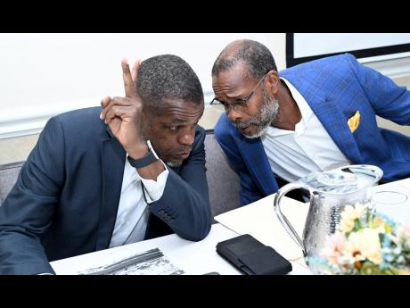 
Kingston Properties Limited CEO Kevin Richards (left) and Chairman Garfield Sinclair consult during the company’s annual general meeting on Wednesday, June 12, 2024, at The Courtleigh Hotel in New Kingston.