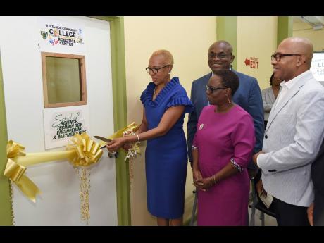 Minister of Education and Youth Fayval Williams (left) cutting the ribbon to officially open the STEM Robotics Centre at Excelsior Community College (ECC)’s Eureka Road location on Thursday. Looking on are Philmore McCarthy (second left), principal, ECC,